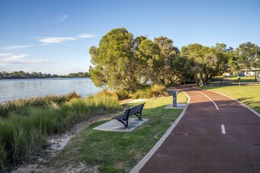 Rossmoyne banliyösündeki ağaç tepe örtüsünün altında 16 Mart 2021 'de Canning Nehri' nin yanındaki kırmızı yol paylaşıldı.