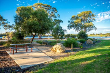 Piknik masası ve nehir kenarındaki bahçedeki banklar Shelley banliyösündeki Canning Nehri 'nin yanında, Perth, Avustralya, 16 Mart 2021
