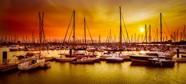 Sailing boats at harbor at orange sunset in La Rochelle, France clipart