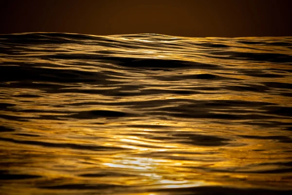 Goldene glatte Wellen auf See Stockbild