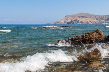 Deniz dalgaları kayalara çarpıyor.