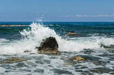 Deniz dalgaları kayalara çarpıyor.