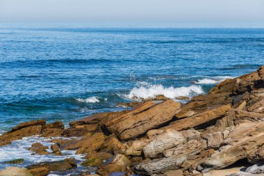 Deniz veya okyanus dalgalarının ve bazı kayaların havadan görünüşü.