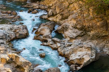 Kanyon boyunca akan bir dağ nehri manzarası.