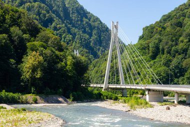 Dağlık bölgede dağ nehri üzerinde kablo destekli köprü otoyolu..
