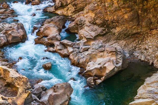 Kanyon boyunca akan bir dağ nehri manzarası.
