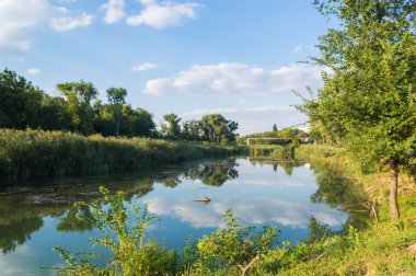 Öğleden sonra gölü ve öğleden sonra gökyüzü yansımalarla dolu.