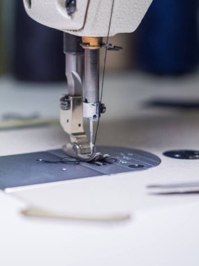 Yakından bak. Dikiş makinesinin mekanizması, makinenin metal parçası. Alçak alan derinliği. Teçhizat fabrikası. Tekstil endüstrisi kavramı.