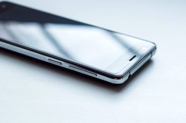 Yüzeyde beyaz arkaplanda izole siyah, beyaz ekranlı akıllı telefon var..
