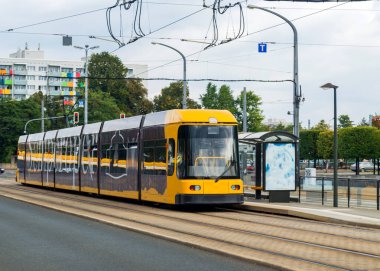 Dresden, Almanya 'da güzel bulutlu bir sonbahar gününde modern sarı tramvay