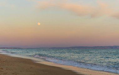 Denizin üzerinde ay doğuyor.