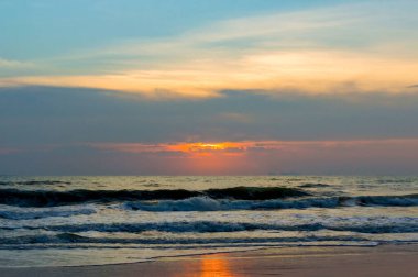 Gün batımlı kumsal. Dramatik gökyüzü ve deniz kıyısı