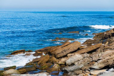 Deniz veya okyanus dalgalarının ve bazı kayaların havadan görünüşü.