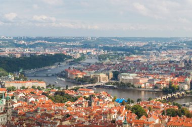 Prag şehrinin kırmızı çatıları. Prag 'ın panoramik manzarası, Çek Cumhuriyeti. Şehirde bulutlu mavi gökyüzü olan bir yaz günü. Praha, Avrupa 'nın güzel Praha kentindeki birçok çatı