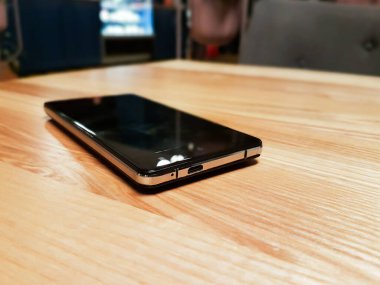 Yüzeyde beyaz arkaplanda izole siyah, beyaz ekranlı akıllı telefon var..