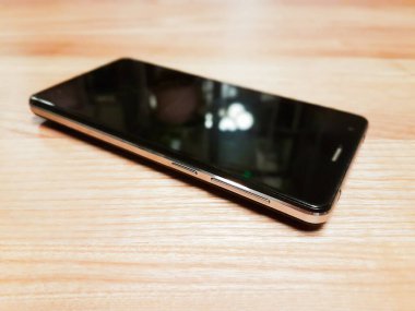 Yüzeyde beyaz arkaplanda izole siyah, beyaz ekranlı akıllı telefon var..