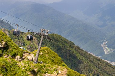 Yaz dağlarında kablolu bir araba. Yaz mevsiminde dağların manzarası