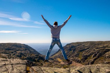Mutlu Adam dağlardan bulutlara zıplıyor Yaşam tarzı seyahat duygusal coşku başarı kavramı macera kavramı açık havada aktif tatiller.