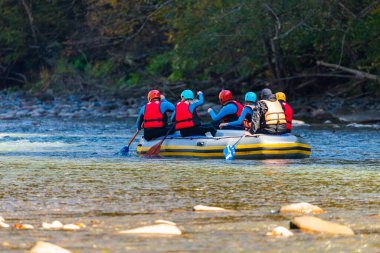 Bir grup genç dağ nehrinde rafting yapıyor..