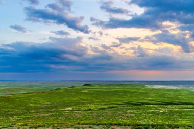 Bozkırda bulutların olduğu manzaralı günbatımı.
