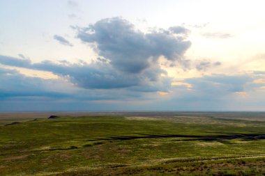 Bozkırda bulutların olduğu manzaralı günbatımı.