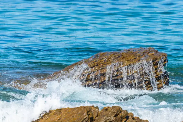 Deniz veya okyanus dalgalarının ve bazı kayaların havadan görünüşü.