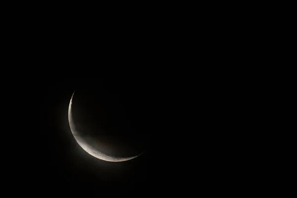 New moon on dark sky in cloudy weather