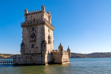 Manzaralı Belem Kulesi ve Tagus Nehri 'nde alçak gelgitlerle süslenmiş ahşap köprü. Torre de Belem, Lizbon 'un Unesco Mirası ve simgesi ve Lizbon, Belem Bölgesi, Portekiz' in en çok ziyaret edilen yeridir..
