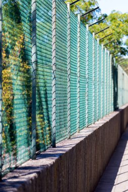Tel örgü çit ve mavi gökyüzü arkaplanlı yasak bölge tabelası.