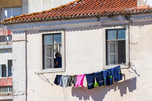 Portekiz, Lizbon, 09 Ekim 2018: Lizbon, Portekiz 'de bir sokakta asılı keten. Kuruması için pencereden sarkan giysileri olan bir mimari..