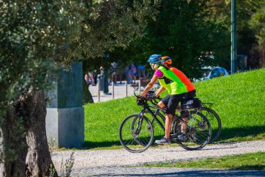 Portekiz, Lizbon, 09 Ekim 2018: Sağlıklı yaşam tarzı - bisiklete binen insanlar. Spor insanları için şehir parkı.