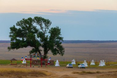 Kalmykia 'daki kutsal ağaç. Tarikat nesnesnesinin girişindeki bir kapı veya kemerin silueti.