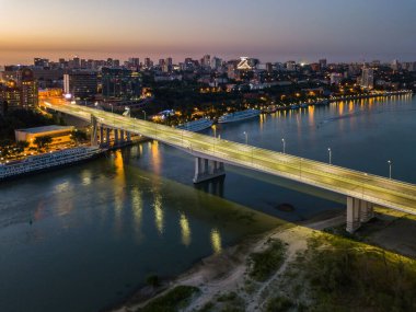 Rostov-on-Don, Rusya - 06 Temmuz 2020: Günbatımında Voroshilovsky köprüsü ve Rusya yazılı metni olan Rostov-Arena Stadyumu 'nun sol kıyısının manzarası.