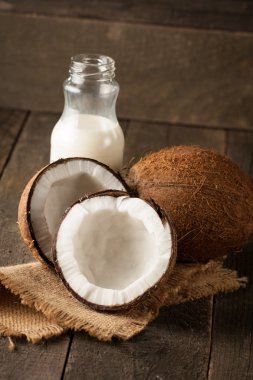 Olgun yarı ahşap bir arka plan üzerine Hindistan cevizi kesti. Olgun yarı ahşap bir arka plan üzerine Hindistan cevizi sütü ile kesmek