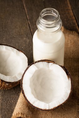 Olgun yarı ahşap bir arka plan üzerine Hindistan cevizi kesti. Olgun yarı ahşap bir arka plan üzerine Hindistan cevizi sütü ile kesmek