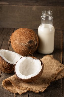 Olgun yarı ahşap bir arka plan üzerine Hindistan cevizi kesti. Olgun yarı ahşap bir arka plan üzerine Hindistan cevizi sütü ile kesmek