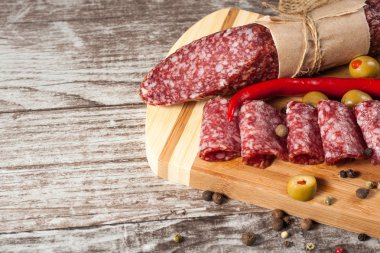 Zeytin ve ahşap zemin üzerine baharat ile İtalyan salamı