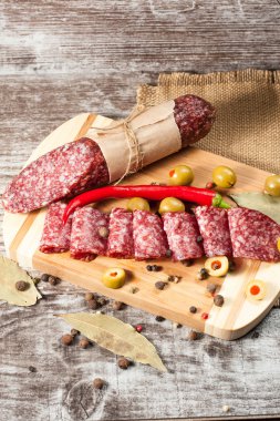 Zeytin ve ahşap zemin üzerine baharat ile İtalyan salamı