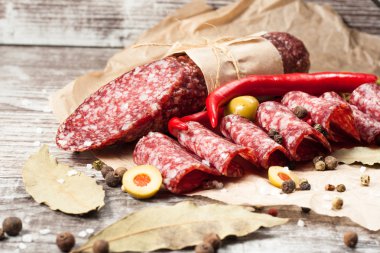 Zeytin ve ahşap zemin üzerine baharat ile İtalyan salamı