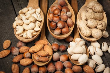 Ahşap arka plan üzerinde sağlıklı karışımı fındık. Badem, fındık, kaju fıstığı, fıstık, Brezilya fındık