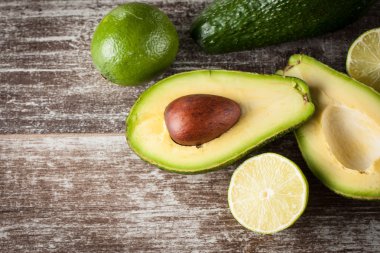 Ahşap masa üzerinde bir avokado ve avokado yağı close-up. Sağlıklı gıda kavramı.