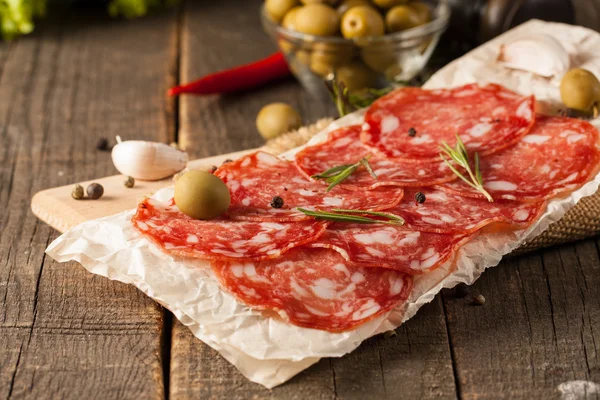 Salsicha Chorizo e salame, corte fino. salame espanhol no fundo de madeira com especiarias, páprica, pimenta. Comida picante. Pimenta. — Fotografia de Stock