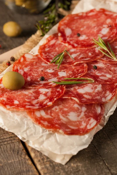 Salsicha Chorizo e salame, corte fino. salame espanhol no fundo de madeira com especiarias, páprica, pimenta. Comida picante. Pimenta. — Fotografia de Stock