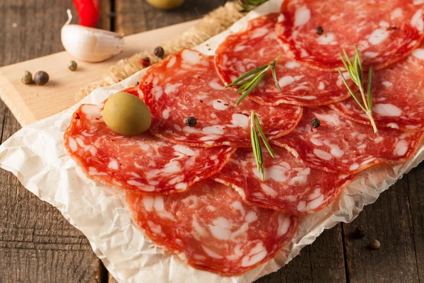 Chorizo sausage and salami, thin cut. spanish salami on the wood background with spices, paprika, pepper. Spicy food. Chili. — Stock Photo, Image