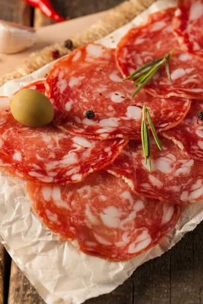 Chorizo worst en salami, dun gesneden. Spaanse salami op houtondergrond met specerijen, paprika, peper. Pittig eten. Chili. — Stockfoto