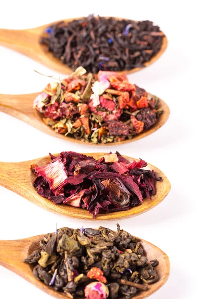 Torra te i träskedar på trä rustika bakgrund. Bladen av rött, grönt och svart te. Makro foto. Rustik stil och koncept. — Stockfoto