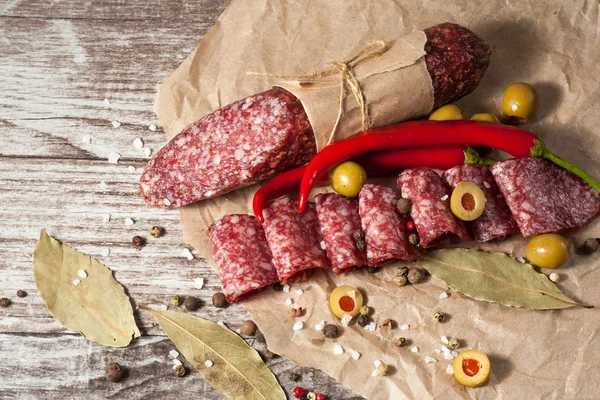 Salami italien aux olives et épices sur fond de bois — Photo