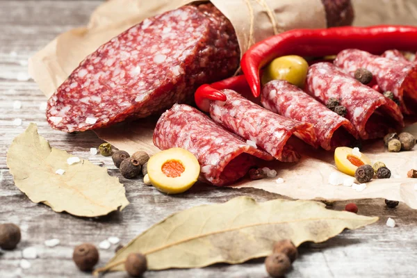 Salami italien aux olives et épices sur fond de bois — Photo