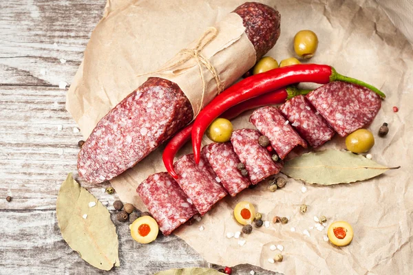 Salami italien aux olives et épices sur fond de bois — Photo