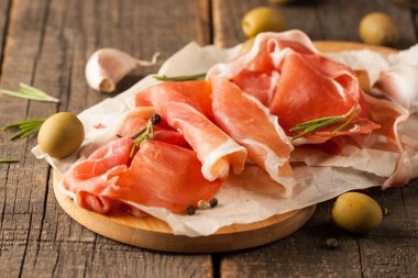 prosciutto ile karışık zeytin ve ahşap kesme tahtası üzerinde kırmızı biber ince dilim closeup